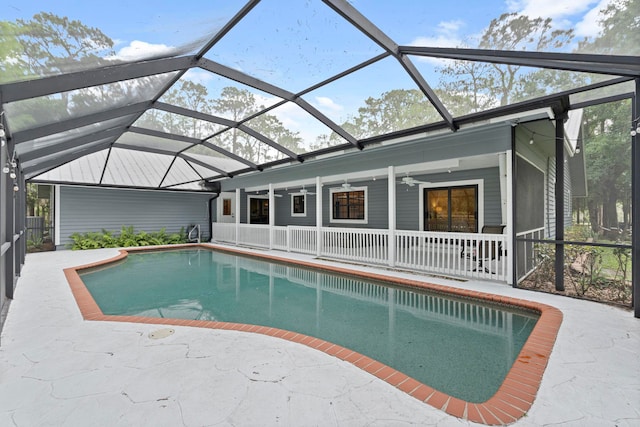 view of swimming pool featuring glass enclosure, ceiling fan, and a patio area