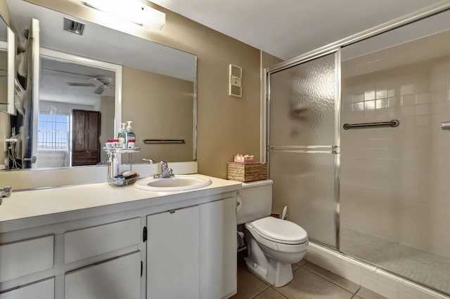 bathroom with tile patterned floors, walk in shower, vanity, ceiling fan, and toilet