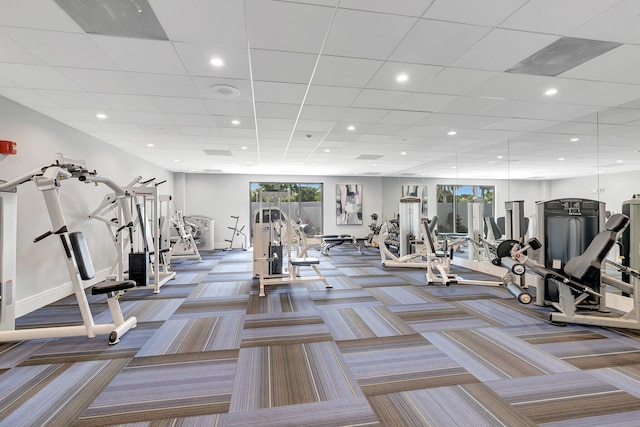 exercise room featuring carpet flooring and a paneled ceiling