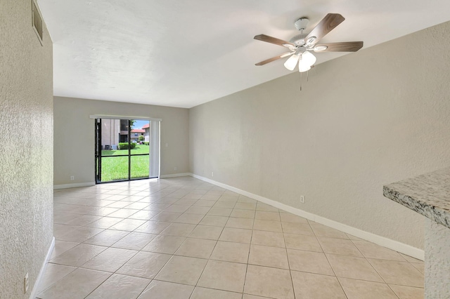 spare room with light tile patterned flooring and ceiling fan