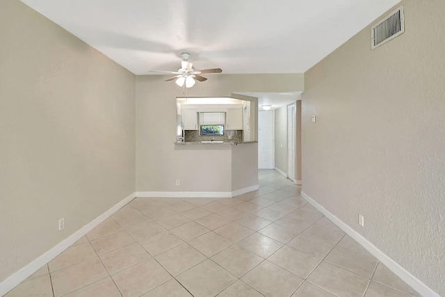 empty room featuring light tile patterned floors and ceiling fan