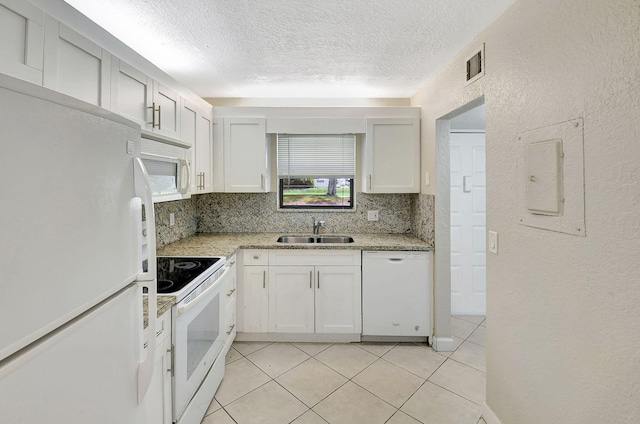 kitchen with white appliances, white cabinetry, sink, light tile patterned flooring, and tasteful backsplash