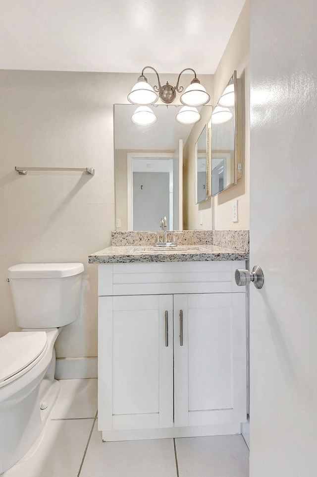 bathroom featuring tile patterned flooring, toilet, and vanity