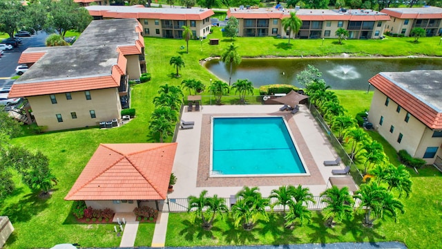 view of swimming pool featuring a yard and a water view