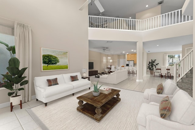 living room with light tile patterned floors, a high ceiling, and ceiling fan