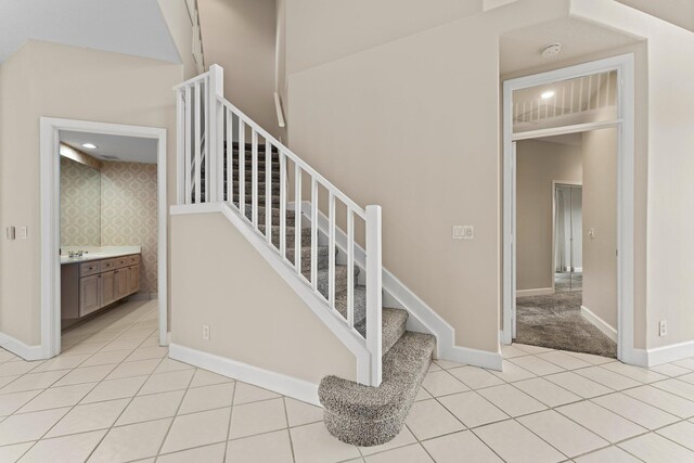 stairs featuring sink and tile patterned floors