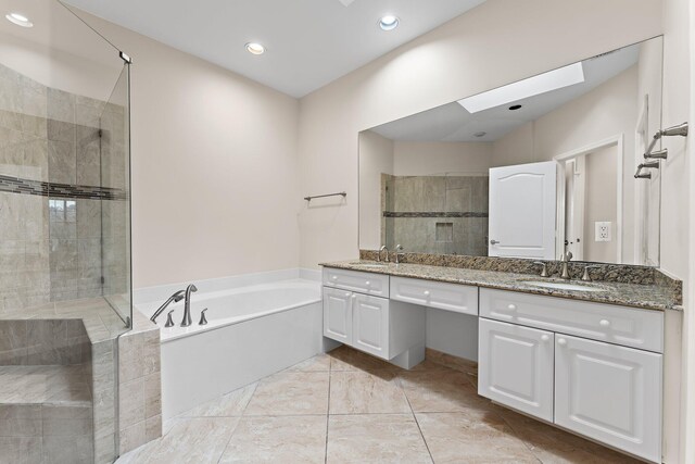 bathroom featuring vanity, a skylight, and shower with separate bathtub