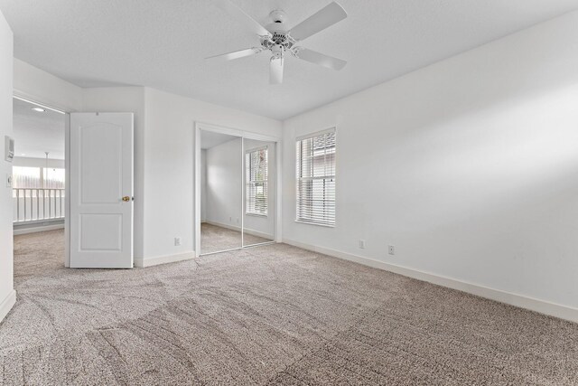 unfurnished bedroom with a closet, ceiling fan, and light carpet