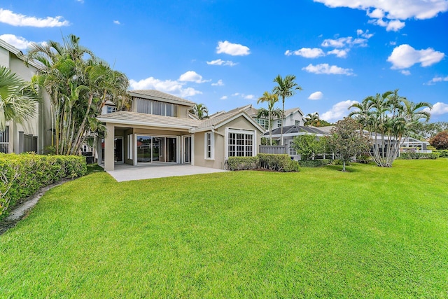 rear view of house with a yard and a patio