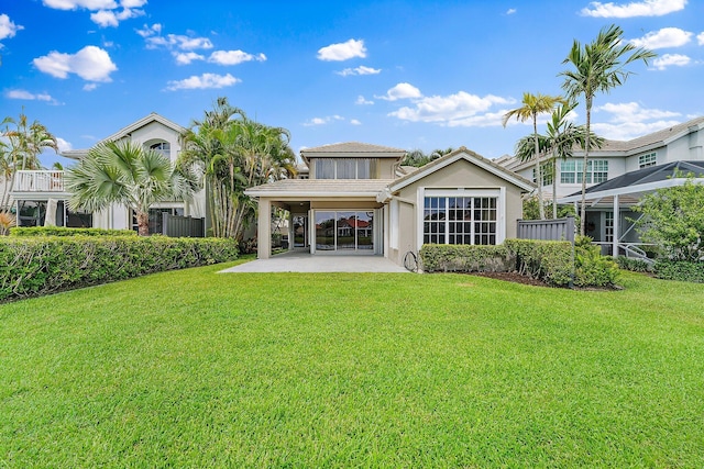 rear view of house with a lawn and a patio