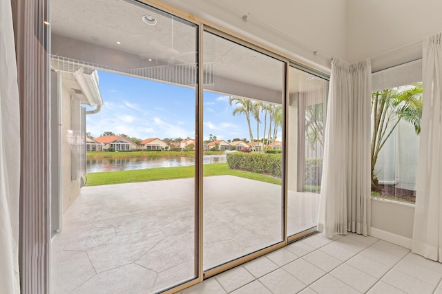 doorway with a water view and light tile patterned flooring