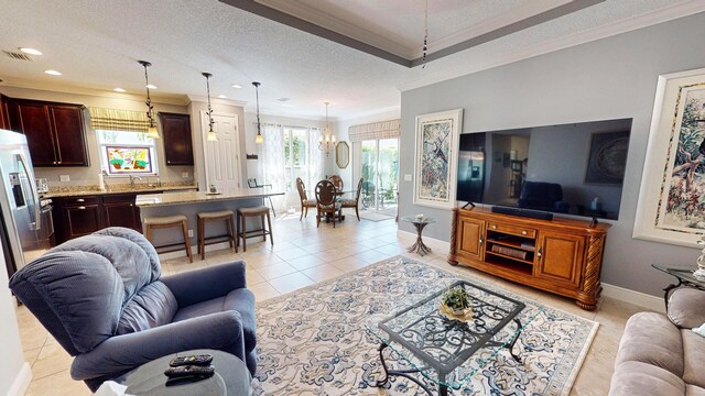 tiled living room with a textured ceiling, a wealth of natural light, and ornamental molding