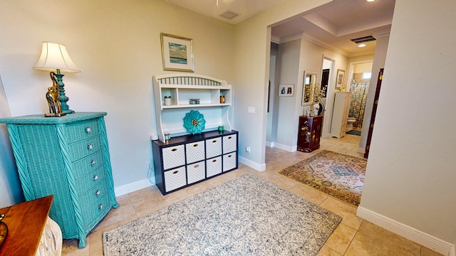 hall featuring light tile patterned floors and ornamental molding