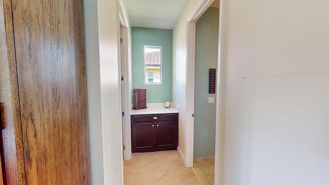 hallway featuring light colored carpet