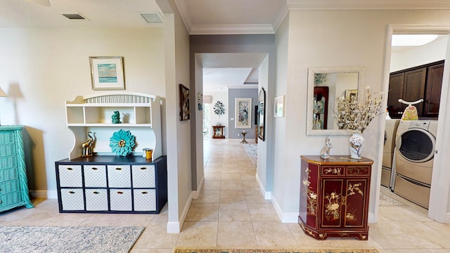 hallway featuring washer and clothes dryer, ornamental molding, and light tile patterned floors