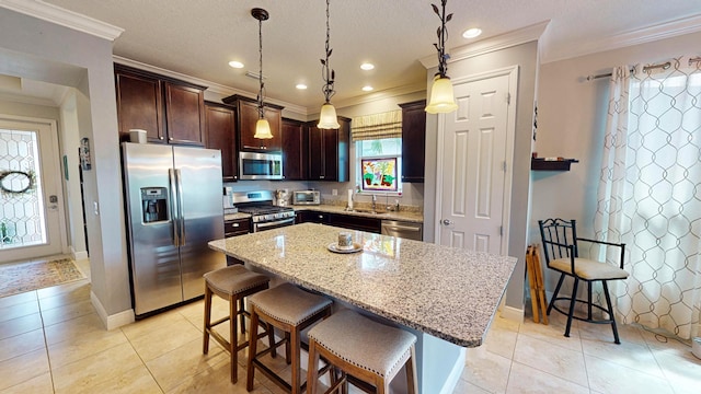 kitchen with a breakfast bar area, hanging light fixtures, a kitchen island, and stainless steel appliances