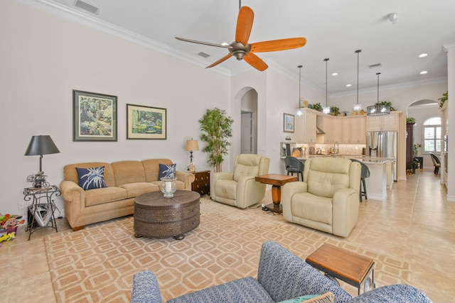 tiled living room with ceiling fan and ornamental molding