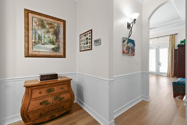 hall featuring french doors, light hardwood / wood-style floors, and crown molding