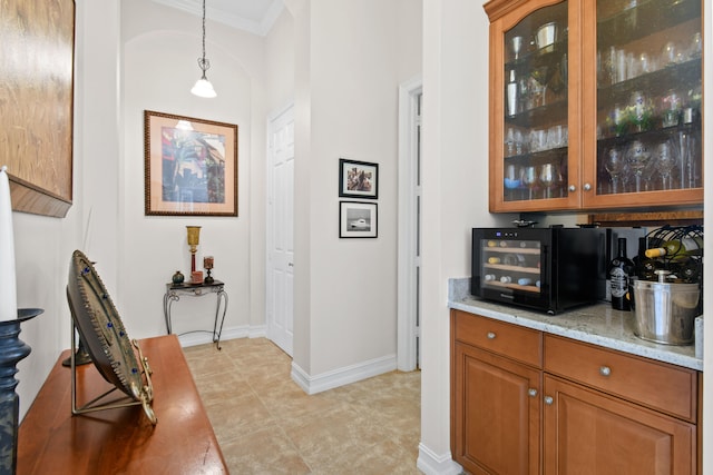 bar featuring pendant lighting, light stone counters, and ornamental molding