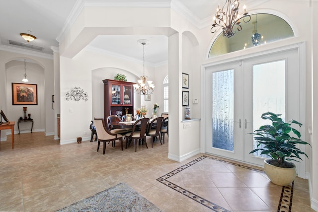 tiled foyer entrance with an inviting chandelier, french doors, and ornamental molding