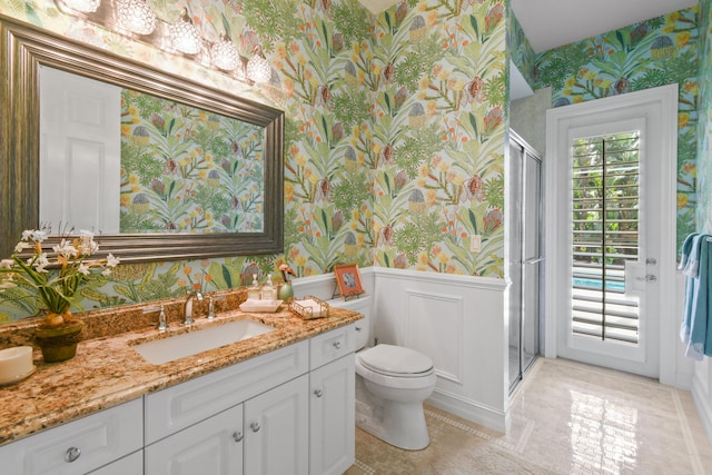 bathroom with tile patterned floors, vanity, toilet, and an enclosed shower