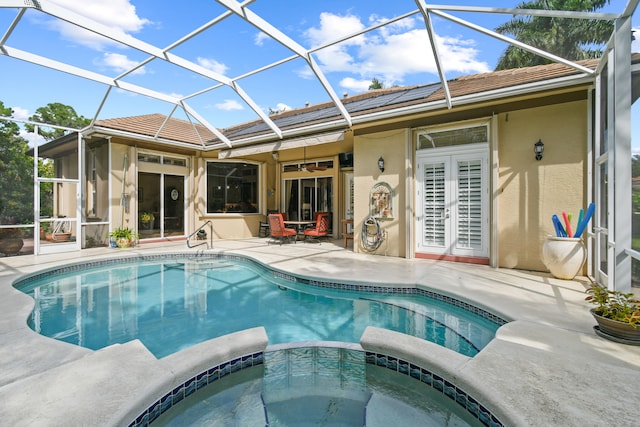 view of swimming pool with glass enclosure, a patio area, ceiling fan, and an in ground hot tub