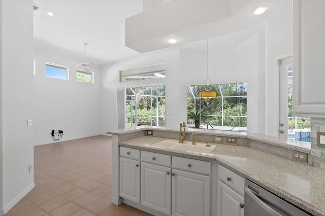 kitchen with white cabinets, sink, stainless steel dishwasher, ceiling fan, and decorative light fixtures