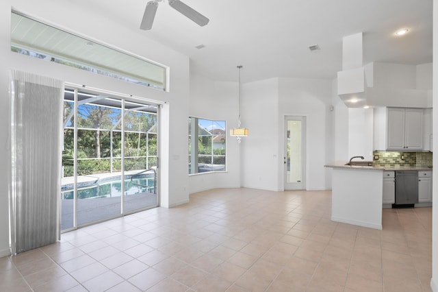 interior space featuring ceiling fan, light tile patterned floors, tasteful backsplash, pendant lighting, and white cabinets