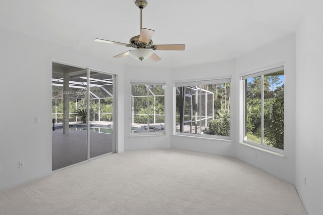 unfurnished sunroom featuring a wealth of natural light and ceiling fan