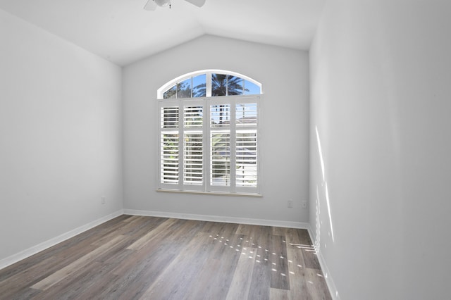 empty room with hardwood / wood-style floors, ceiling fan, a healthy amount of sunlight, and vaulted ceiling