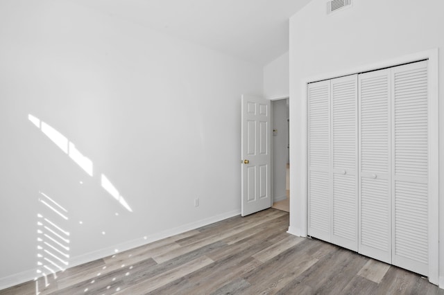 unfurnished bedroom with a closet and light hardwood / wood-style flooring