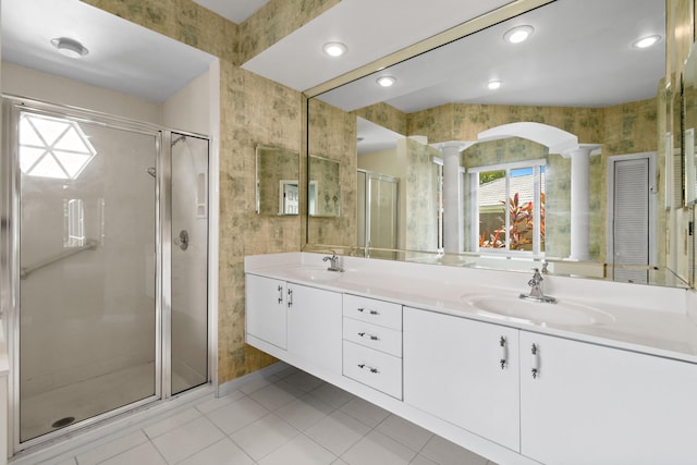 bathroom with tile patterned flooring, vanity, an enclosed shower, and ornate columns