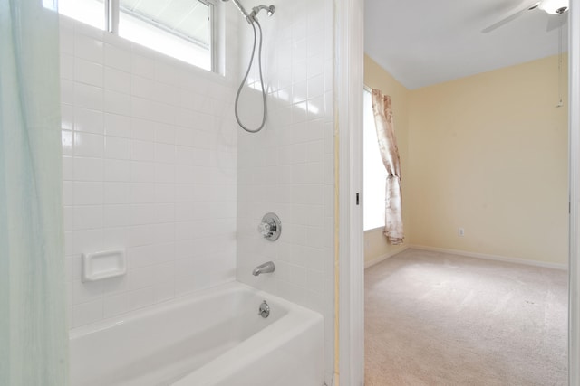 bathroom with lofted ceiling and tiled shower / bath