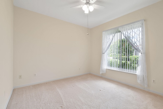 carpeted spare room featuring ceiling fan