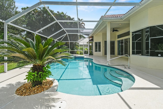 view of pool featuring glass enclosure, ceiling fan, and a patio