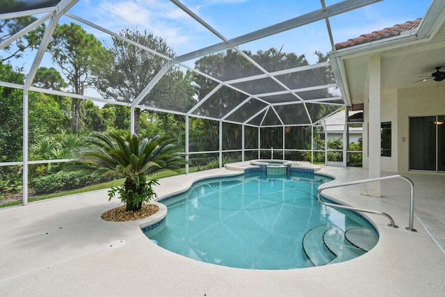 view of pool with glass enclosure, ceiling fan, a patio area, and an in ground hot tub