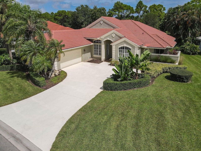 mediterranean / spanish house featuring a front yard and a garage