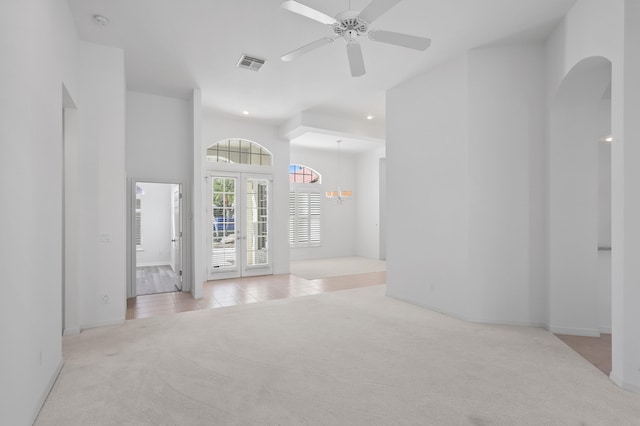 unfurnished room featuring ceiling fan, light colored carpet, and french doors