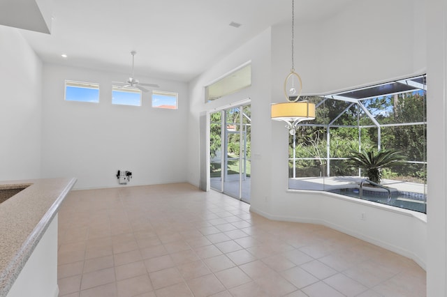 unfurnished dining area featuring ceiling fan and light tile patterned floors