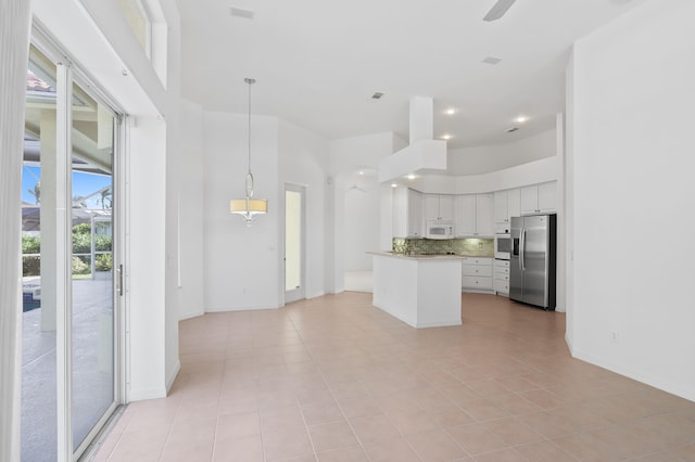 kitchen with backsplash, stainless steel appliances, ceiling fan, light tile patterned floors, and white cabinets