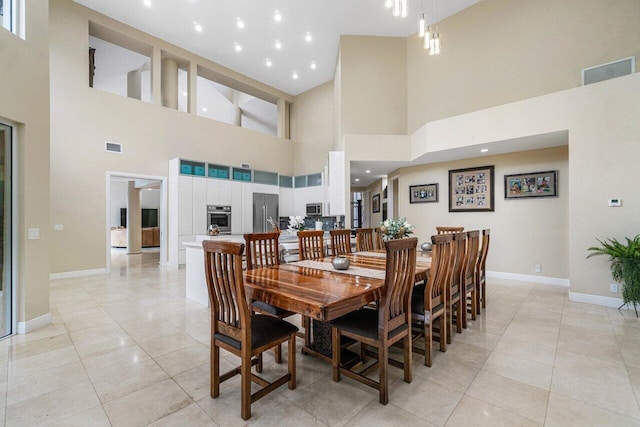 tiled dining space featuring high vaulted ceiling