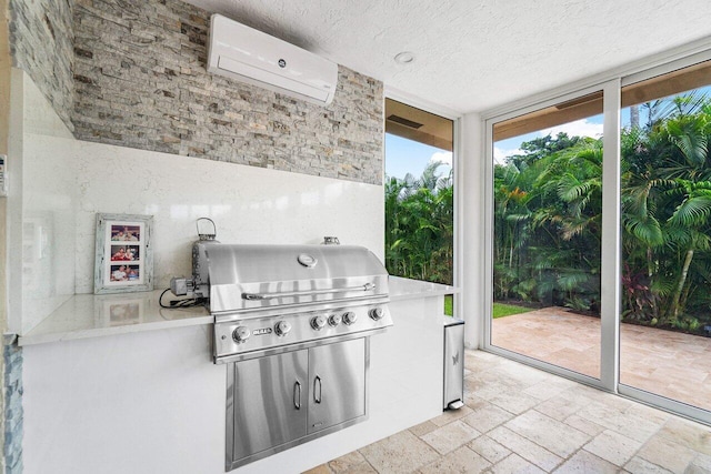 view of patio / terrace featuring exterior kitchen, a wall unit AC, and a grill