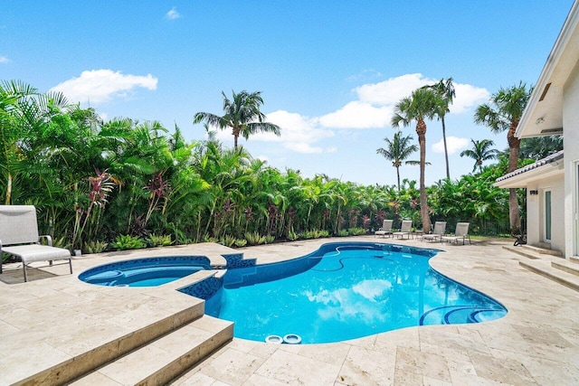 view of swimming pool featuring a patio and an in ground hot tub