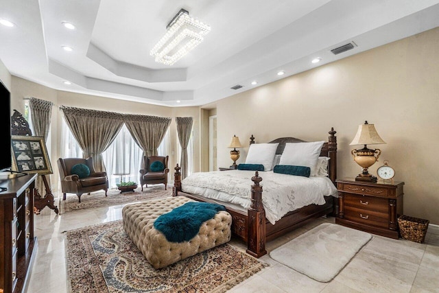 bedroom featuring a raised ceiling and a chandelier