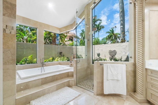 bathroom with tile patterned floors, independent shower and bath, plenty of natural light, and vanity