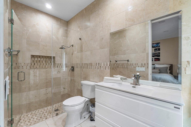 bathroom with toilet, tile patterned flooring, a shower with door, vanity, and tile walls