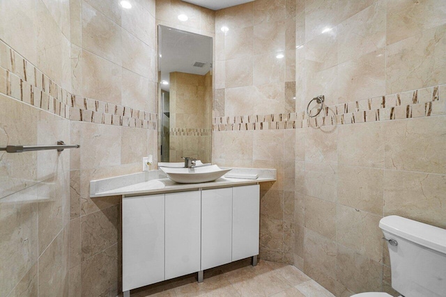 bathroom with tile walls, toilet, and vanity