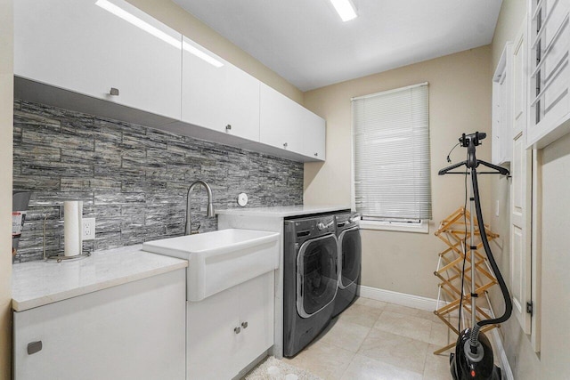 washroom with light tile patterned floors, cabinets, separate washer and dryer, and sink