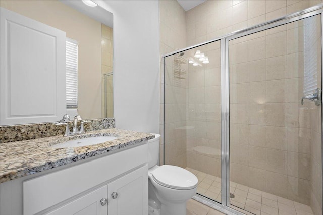 bathroom with vanity, toilet, and a shower with door