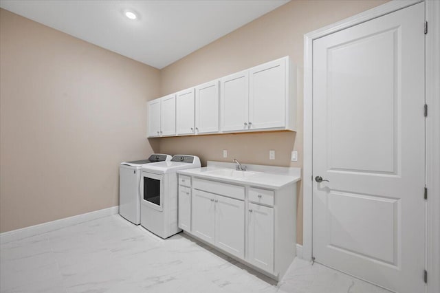 laundry area featuring cabinets, separate washer and dryer, and sink